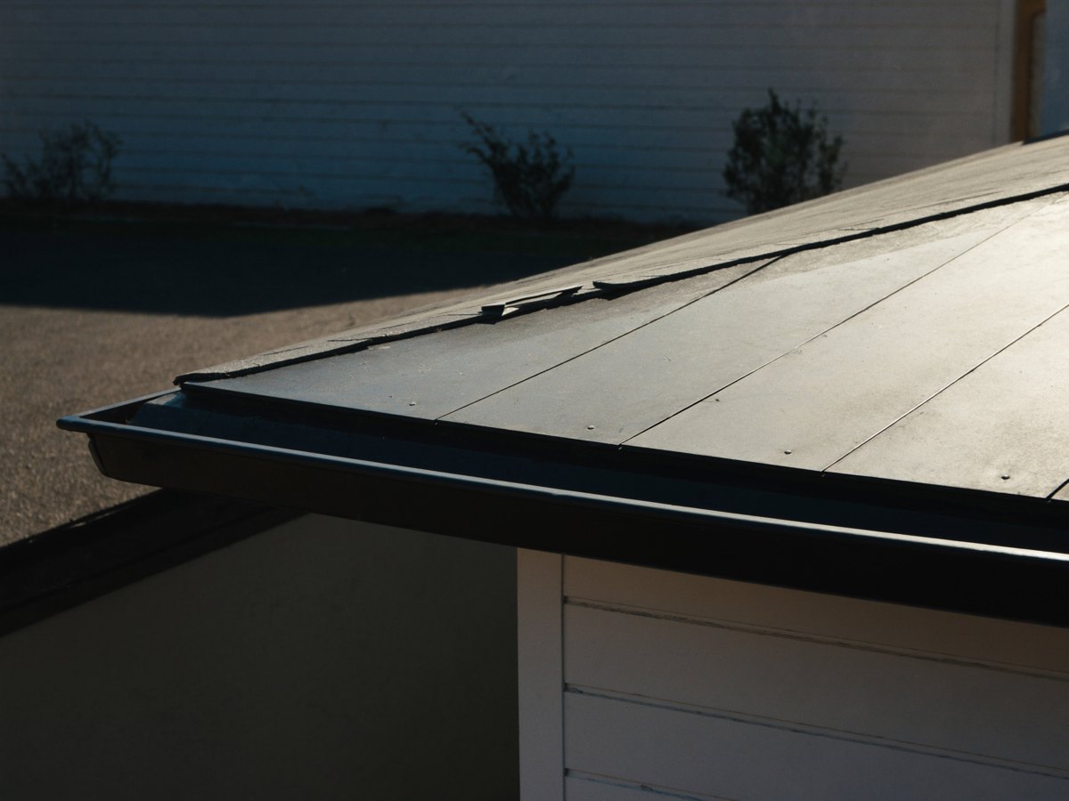 Close-up of a dark standing seam metal roof edge and gutter